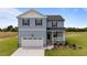Charming two-story home featuring a covered porch, attached garage, and beautifully landscaped front yard at 55 Diamond Creek Dr, Zebulon, NC 27597