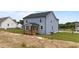 Home with light blue siding has a covered back porch and mature trees in back at 55 Diamond Creek Dr, Zebulon, NC 27597