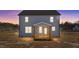 Back exterior of a two-story home at dusk, with light-blue vinyl siding, covered porch and ample windows at 55 Diamond Creek Dr, Zebulon, NC 27597