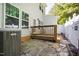 Backyard with a stone patio and deck with partial view of the home's exterior at 809 Davidson Point Rd, Cary, NC 27513