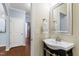 Charming bathroom featuring a pedestal sink, a large mirror, and wood-look floors at 809 Davidson Point Rd, Cary, NC 27513