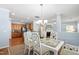 Bright dining area with a modern chandelier, white table, and views of living spaces at 809 Davidson Point Rd, Cary, NC 27513