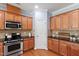 Well-lit kitchen featuring a gas range, stainless steel microwave, and wooden cabinets at 809 Davidson Point Rd, Cary, NC 27513