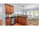 Open-concept kitchen with stainless steel dishwasher and sink, and a view into the dining and living rooms at 809 Davidson Point Rd, Cary, NC 27513