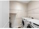 Functional laundry room with washer, dryer, and storage shelving at 809 Davidson Point Rd, Cary, NC 27513