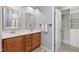 Bright main bathroom featuring double sinks, walk-in closet, framed mirrors and a tile floor at 809 Davidson Point Rd, Cary, NC 27513