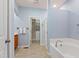 Well-lit main bathroom with soaking tub, walk-in shower, walk-in closet, and wood vanity at 809 Davidson Point Rd, Cary, NC 27513