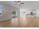 Open-concept living room with light hardwood floors leading to a modern kitchen and sliding glass door at 22 Laramie Ln, Selma, NC 27576