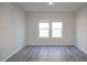 Simple bedroom with grey flooring and two windows at 332 Squirrel Oaks Ln, Garner, NC 27529