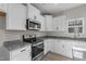 Modern kitchen features white cabinetry, granite countertops, and stainless steel appliances at 41 Red River Dr, Selma, NC 27576