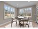 Cozy dining area with round table, four chairs, a rug, and bright windows overlooking a scenic outdoor view at 55 Basil Ct, Franklinton, NC 27525