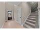 Bright entryway with hardwood floors, dark door, and carpeted staircase at 55 Basil Ct, Franklinton, NC 27525