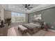 Comfortable main bedroom featuring a ceiling fan, tray ceiling, large window, and neutral decor at 55 Basil Ct, Franklinton, NC 27525