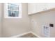 Laundry room with white cabinets and tiled floor at 927 Micro W Rd, Selma, NC 27576