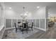 Cozy dining room with modern wainscoting, stylish chandelier, and views of the surrounding neighborhood at 184 Dereham Ln, Garner, NC 27529