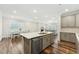 Kitchen with stainless steel appliances and large center island seamlessly transitioning to dining and living areas at 2432 Pikes Peak Dr, Raleigh, NC 27616