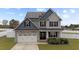 Two-story house with gray siding, stone accents, and solar panels at 38 Locomotive Way, Clayton, NC 27520