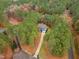 Aerial view of a two-story house nestled in a forest with a long driveway and lush landscaping at 5600 Thornburg Dr, Wake Forest, NC 27587