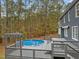 View of back deck, house, and covered pool with wooded backdrop at 5600 Thornburg Dr, Wake Forest, NC 27587