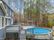 Large backyard with deck, above-ground pool, mature trees, and blue siding at 5600 Thornburg Dr, Wake Forest, NC 27587