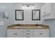 Bathroom featuring double vanity with granite countertop, decorative mirrors, and white cabinets at 5600 Thornburg Dr, Wake Forest, NC 27587