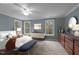 Staged bedroom boasts carpeting, natural light from large windows, and built-in dresser with staging decorations at 5600 Thornburg Dr, Wake Forest, NC 27587