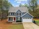 Traditional two-story home with a red front door and attached garage and landscaping at 5600 Thornburg Dr, Wake Forest, NC 27587