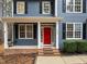Inviting home exterior featuring a red door, black shutters, and a cozy porch swing at 5600 Thornburg Dr, Wake Forest, NC 27587