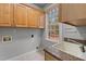 Functional laundry room with ample cabinet space, a sink, and a window at 5600 Thornburg Dr, Wake Forest, NC 27587
