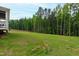 A lush, green backyard extends to a privacy fence line and a dense forest creating a peaceful outdoor space at 617 Darian Woods Dr, Holly Springs, NC 27540