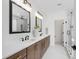 Modern bathroom with double vanity, wood cabinets, framed mirrors, and marble tile flooring at 617 Darian Woods Dr, Holly Springs, NC 27540
