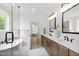 Bright bathroom featuring a freestanding tub, marble tile, and double sink vanity with wood cabinets at 617 Darian Woods Dr, Holly Springs, NC 27540