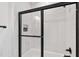 Modern bathroom features a black framed glass shower with a tub and white subway tile surround at 617 Darian Woods Dr, Holly Springs, NC 27540