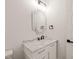 White vanity with marble countertop, modern mirror and light fixtures, and black hardware at 617 Darian Woods Dr, Holly Springs, NC 27540