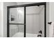 The modern bathroom features a glass-enclosed shower with matte black hardware and gray tile at 617 Darian Woods Dr, Holly Springs, NC 27540