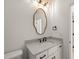 White powder room featuring stone countertop, modern vanity and stylish lighting fixtures at 617 Darian Woods Dr, Holly Springs, NC 27540