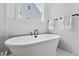 Modern bathtub with black faucet and marble tile surround, plus a sunlit window at 617 Darian Woods Dr, Holly Springs, NC 27540