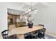 Elegant dining room with wainscotting, a modern chandelier and views into the kitchen at 617 Darian Woods Dr, Holly Springs, NC 27540