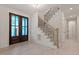 The bright foyer shows the front door and beautiful staircase with dark metal balusters at 617 Darian Woods Dr, Holly Springs, NC 27540