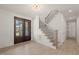 Inviting foyer with beautiful wood-look floors, dark-framed front doors, and an adjacent staircase at 617 Darian Woods Dr, Holly Springs, NC 27540