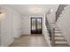 Light, bright foyer with beautiful floors, dark-framed front doors, and an adjacent staircase at 617 Darian Woods Dr, Holly Springs, NC 27540