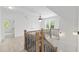 Bright hallway features a modern chandelier and wood and black metal stair railings at 617 Darian Woods Dr, Holly Springs, NC 27540