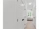 Hallway featuring bright white walls and doors leading to the main bedroom with an accent rug at 617 Darian Woods Dr, Holly Springs, NC 27540