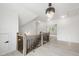 Hallway with hardwood style flooring, a modern chandelier, and wood and black metal stair railings at 617 Darian Woods Dr, Holly Springs, NC 27540