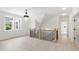 Upstairs hallway with wood floors, black metal railings, natural light and a modern chandelier at 617 Darian Woods Dr, Holly Springs, NC 27540
