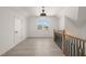 Open hallway with hardwood floors, elegant chandelier, and stylish railing at 617 Darian Woods Dr, Holly Springs, NC 27540