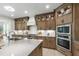 Beautiful kitchen boasts wood cabinets, stainless appliances, a kitchen island, and white countertops at 617 Darian Woods Dr, Holly Springs, NC 27540