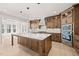 Gourmet kitchen with oversized island, custom cabinets, stainless appliances, and bright lighting at 617 Darian Woods Dr, Holly Springs, NC 27540