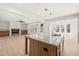 Spacious kitchen with a large island, stainless steel sink, modern lights, and view into the living room at 617 Darian Woods Dr, Holly Springs, NC 27540