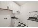 Functional laundry room with white cabinets, black counters, and modern fixtures at 617 Darian Woods Dr, Holly Springs, NC 27540